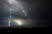 Lightning strikes the east side of The Alvord Desert Thursday, August 8, 2013. The storm formed around The Pueblo Mountains and moved rapidly over the edge of the desert delivering amazing lightning bolts, rumbling thunder and even rain. The Desert, which lies within a rain shadow created by the Coast and Cascade mountain ranges as well the adjacent Steens Mountain, receives as little as 5 inches of rain a year.