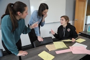 Western Oregon University education students Kate Hern, left, Abbey Busick and McKinsey Jarnagin puzzle through the five pillars of early reading instruction during an activity in a March literacy class.