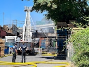 Firefighters continue to hose down the south end of the Shin Shin Foods building in inner North Portland, just off Interstate 5 near the Moda Center exit.