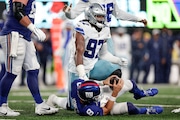 Dallas Cowboys' Osa Odighizuwa, top, gets up after sacking New York Giants quarterback Daniel Jones, bottom, during the first half of an NFL football game, Sunday, Sept. 10, 2023, in East Rutherford, N.J. (AP Photo/Adam Hunger)