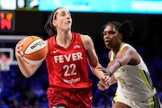 Indiana Fever's Caitlin Clark (22) drives to the basket past Dallas Wings' Teaira McCowan in the first half of a WNBA basketball game Wednesday, July 17, 2024, in Arlington, Texas. (AP Photo/Tony Gutierrez)