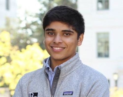 Smiling young man with short, dark hair in fleece jacket.