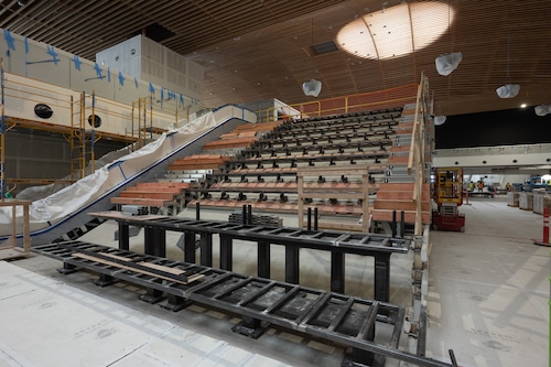 A scene of construction at Portland International Airport, with workers making finishing touches like installing flooring and furniture