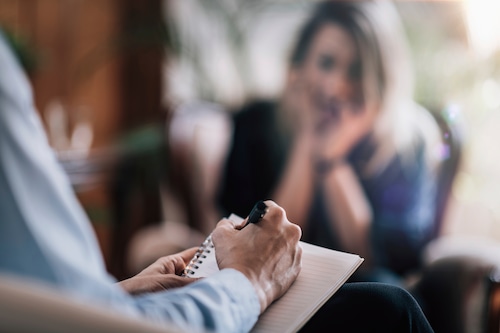 A therapist speaks with a patient during a session