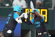 National League's Shohei Ohtani, of the Los Angeles Dodgers, left, celebrates his three-run home with Jurickson Profar, of the San Diego Padres, in the third inning during the MLB All-Star baseball game, Tuesday, July 16, 2024, in Arlington, Texas. (AP Photo/Julio Cortez)